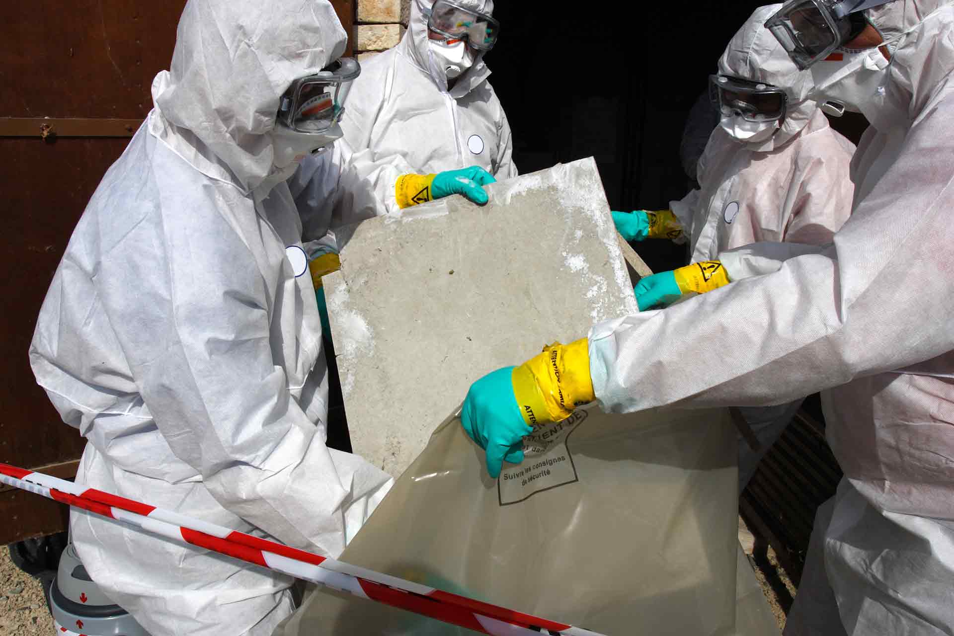 Staff in hazmat suits removing some asbestos